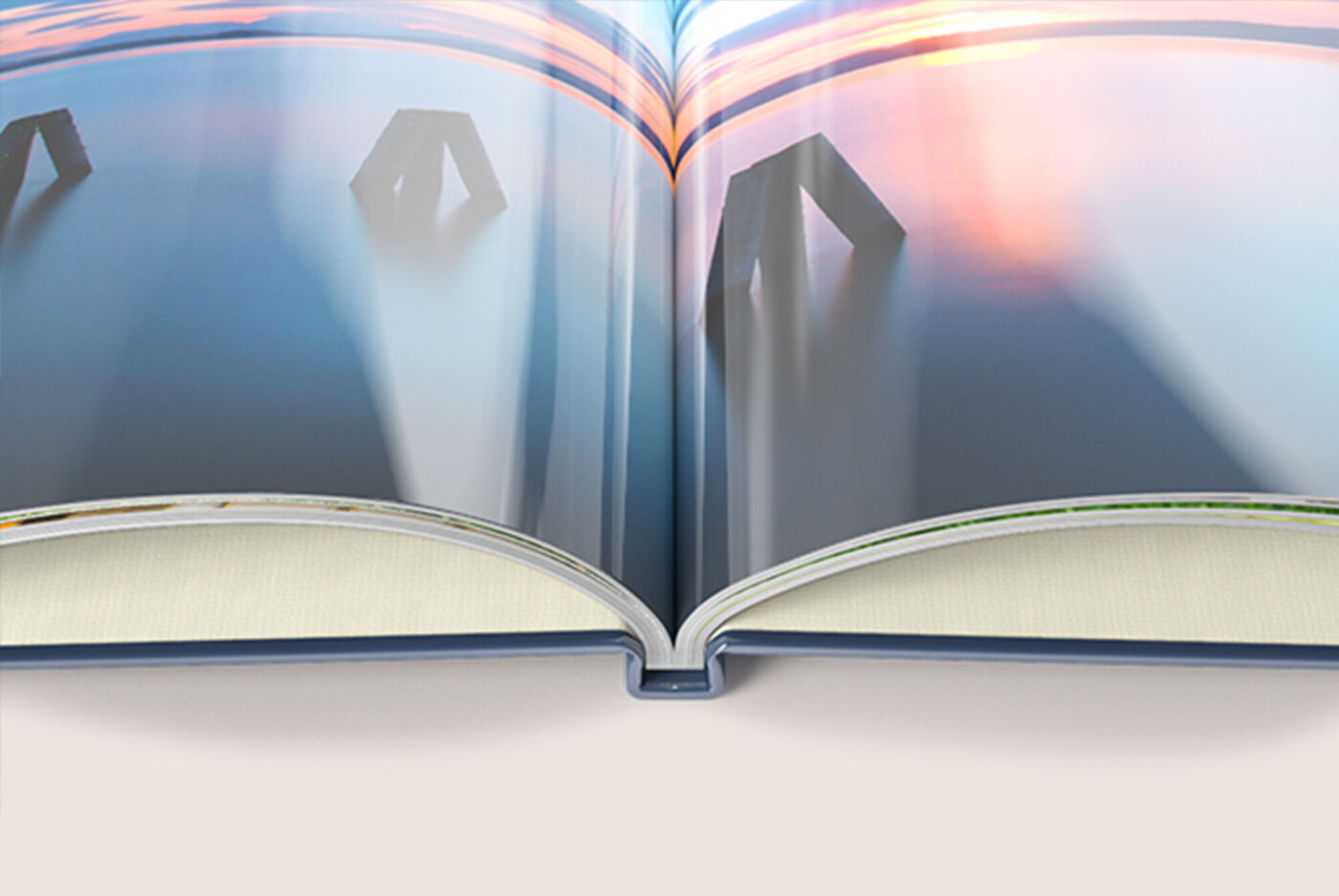 CEWE PHOTOBOOK ouvert avec des couleurs douces et un coucher de soleil rêveur en arrière-plan