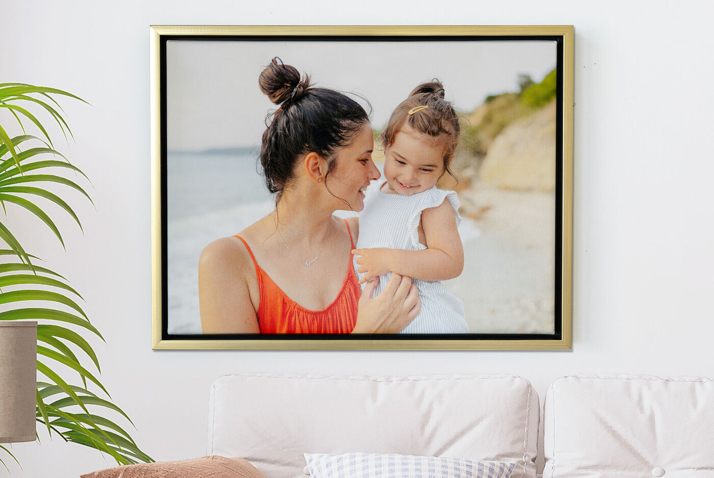 Une mère tient son enfant sur la plage. Ils profitent tous deux de la journée au bord de la mer.