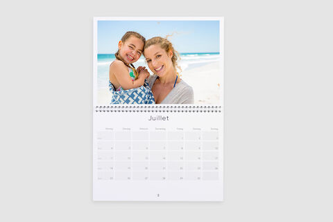 Une feuille de calendrier magique avec une femme joyeuse et un enfant à la plage