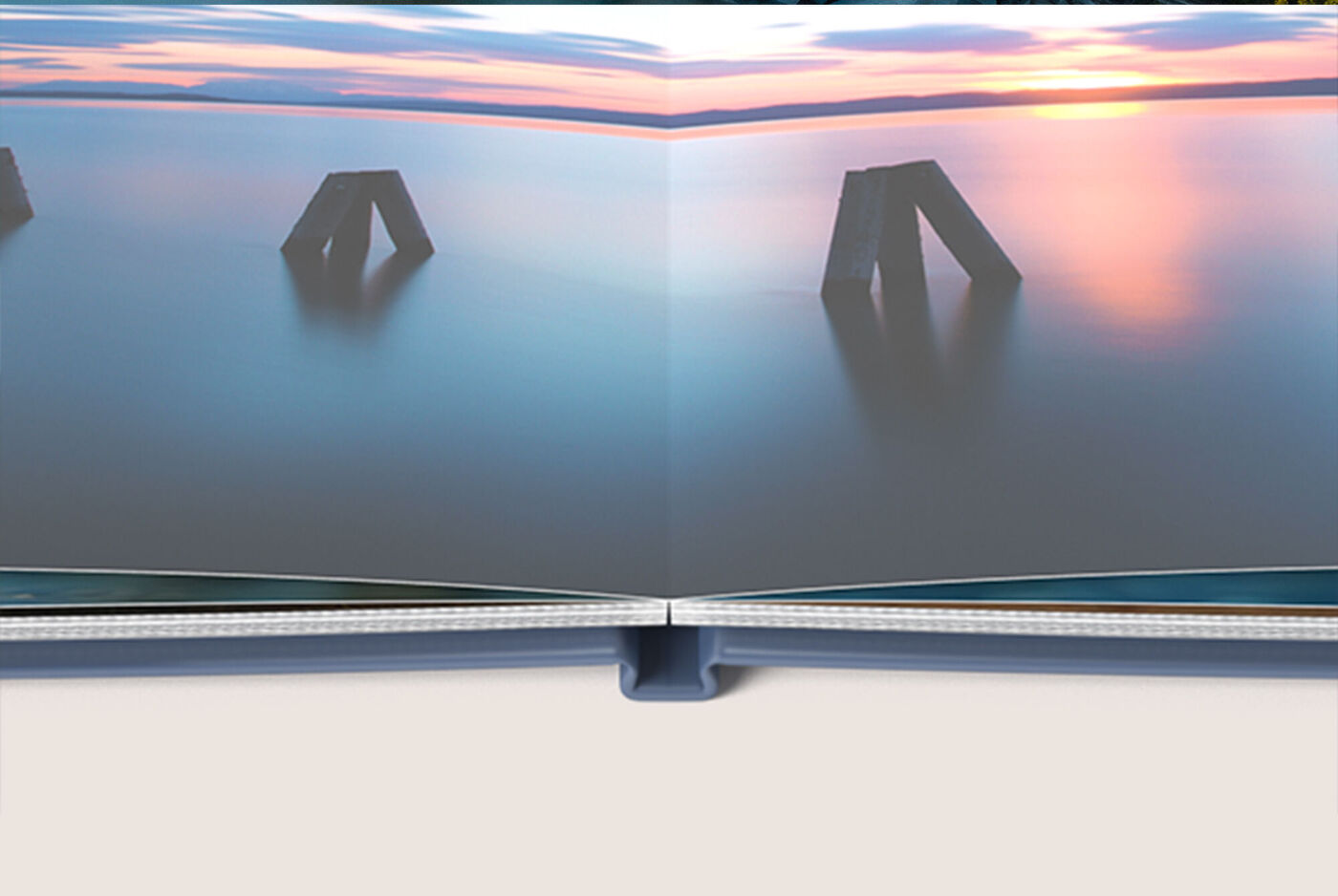 Un livre photo ouvert montre la surface d'eau calme d'un lac avec des piliers en béton sous un coucher de soleil coloré.