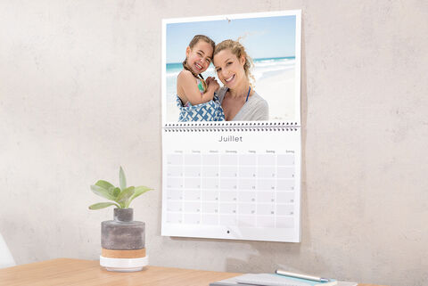 Un beau calendrier photo montre des photos de vacances et un calendrier mensuel.