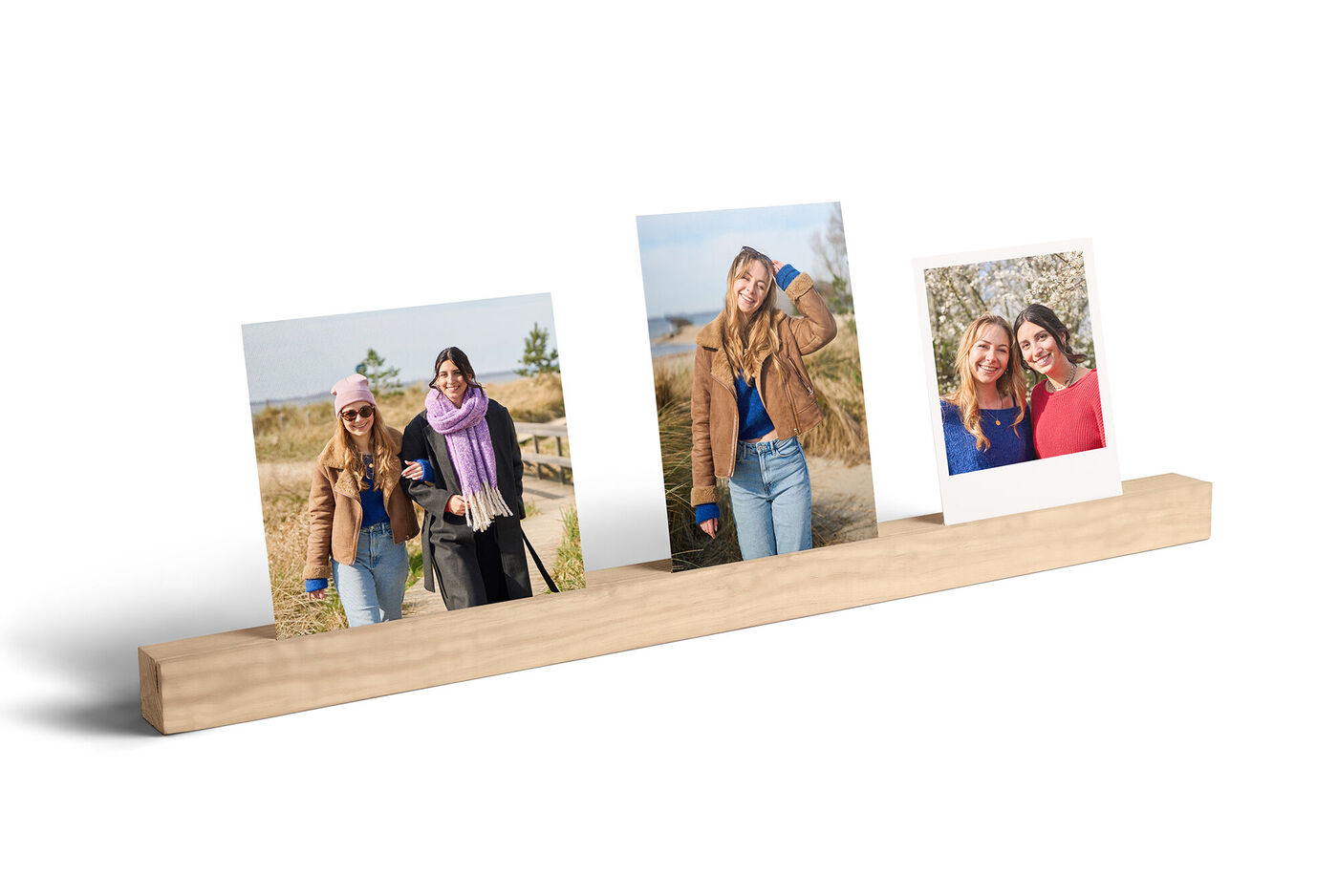 Suppor mural en forme de baguette en bois fendu en son centre sur lequel reposent 3 photos représentant des amis