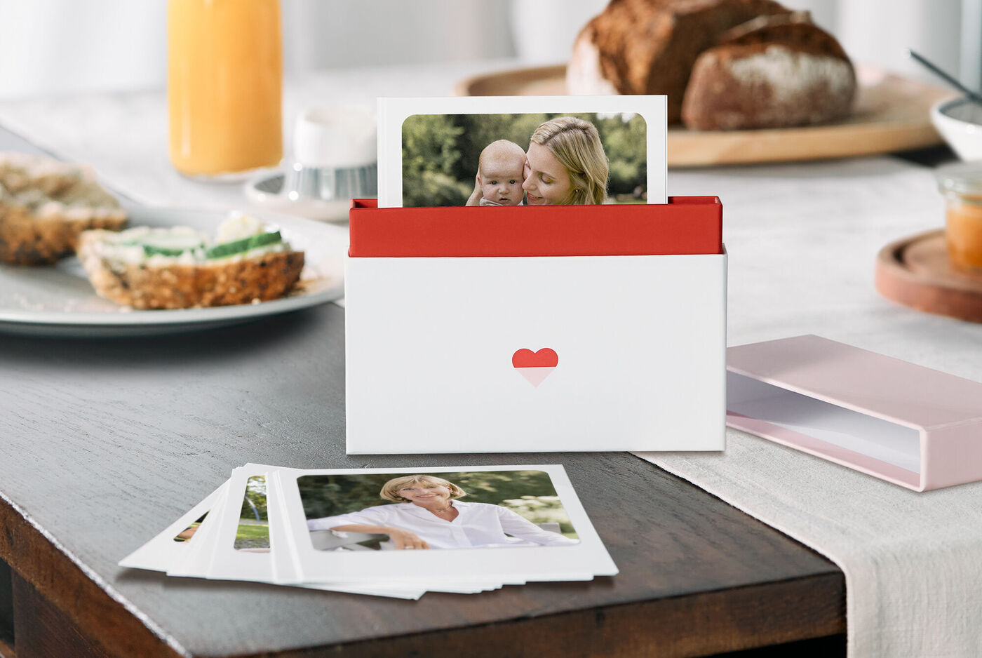 Une boîte rouge contenant des photos sur une table.