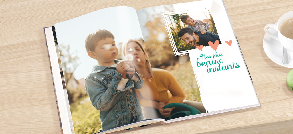 Une famille feuillette le CEWE FOTOBUCH sur une surface en bois