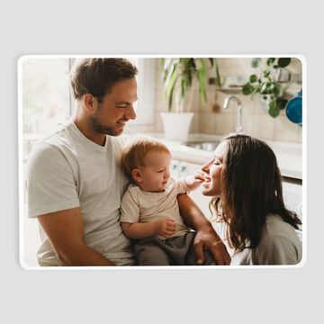 Des parents avec un enfant dans la cuisine, échangeant des regards aimants.