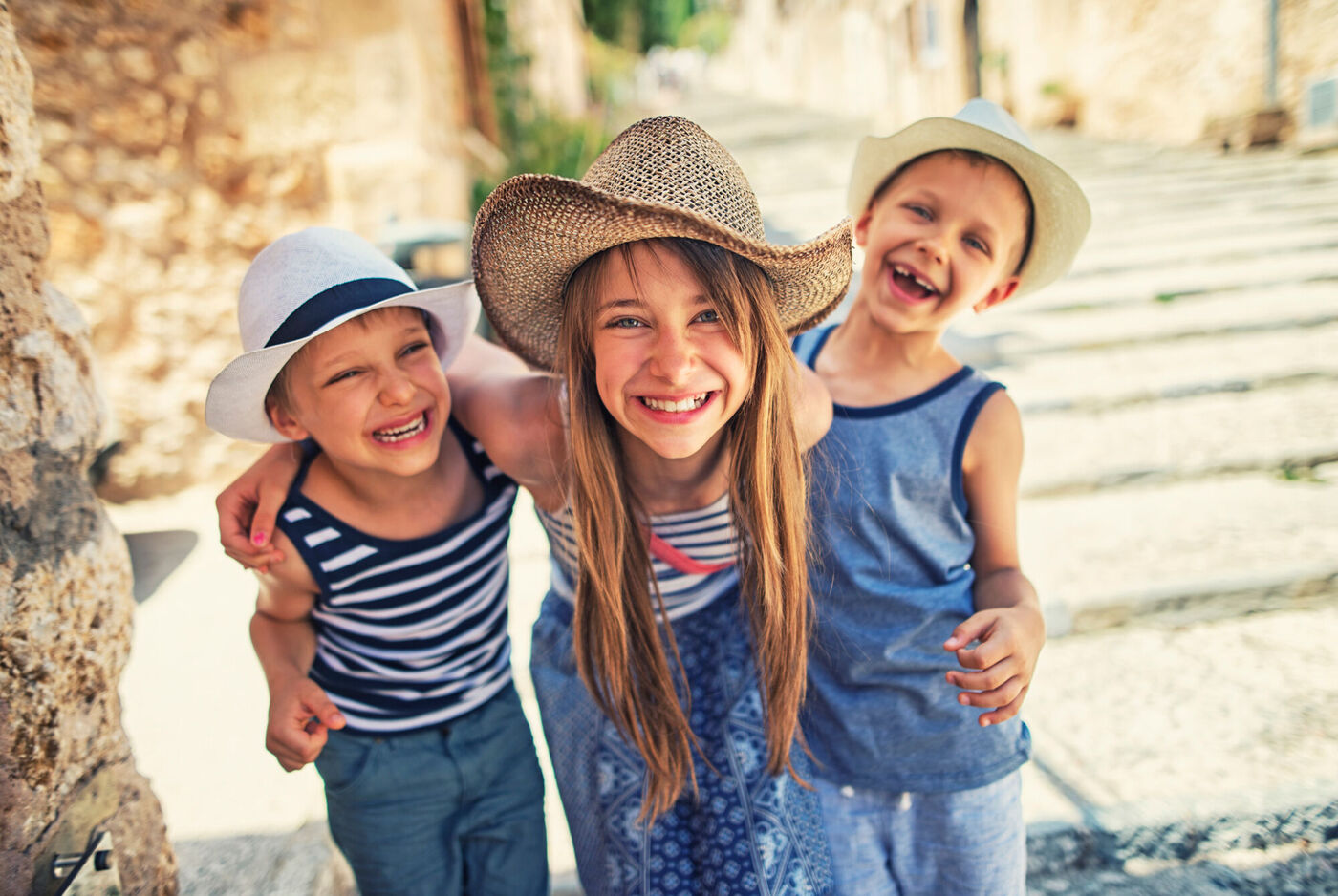 Portrait de 3 enfants heureux portant chacun un chapeau de paille