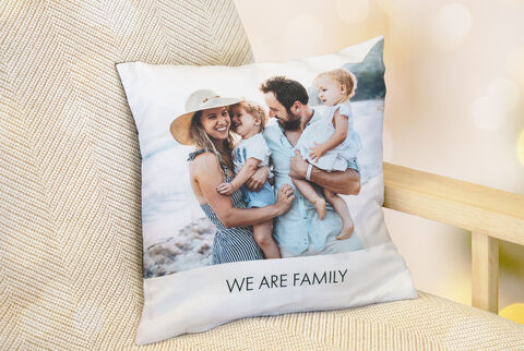 Coussin avec une photo de famille aimante montrant le texte 'NOUS SOMMES UNE FAMILLE'