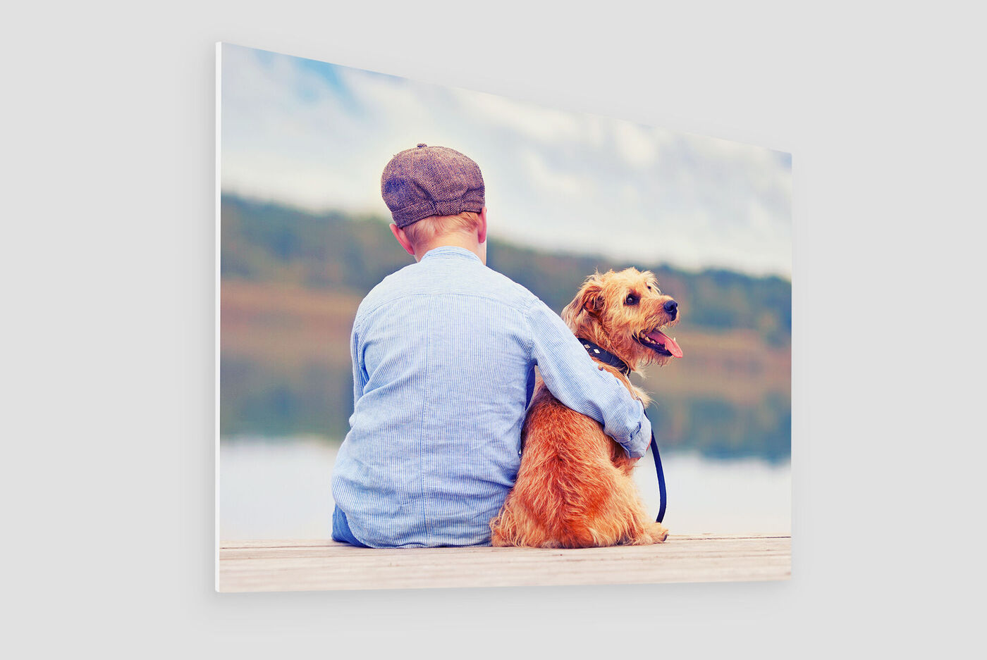 Un garçon assis avec un chien près de l'eau regardant au loin ensemble